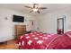 Comfortable bedroom with ceiling fan, dresser, hardwood floors, and a bright red bedspread at 407 Hillcrest Ave, Burlington, NC 27215