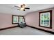 Spacious bedroom with a ceiling fan, neutral carpet and trim, and two large windows bringing in light at 407 Hillcrest Ave, Burlington, NC 27215