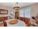 Elegant dining room featuring a chandelier, hardwood floors, and a view of the bright kitchen at 407 Hillcrest Ave, Burlington, NC 27215