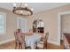Traditional dining room features wooden chandelier, table with seating for six, and a view into the living room at 407 Hillcrest Ave, Burlington, NC 27215