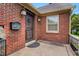 Welcoming brick front entrance featuring a stylish wooden door, exterior lanterns, and a brick wall at 407 Hillcrest Ave, Burlington, NC 27215