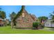 Charming stone and brick house with an American flag, beautiful lawn, and manicured landscaping at 407 Hillcrest Ave, Burlington, NC 27215