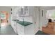 Bright galley kitchen featuring white cabinets, countertops, and appliances at 407 Hillcrest Ave, Burlington, NC 27215