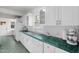 Bright kitchen featuring white cabinets, countertops, and backsplash with stainless steel sink at 407 Hillcrest Ave, Burlington, NC 27215