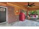 Covered sunroom with a brick wall, vintage refrigerator, swing, and large windows overlooking the lawn at 407 Hillcrest Ave, Burlington, NC 27215