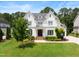 Charming two-story white home boasting a manicured lawn, lush landscaping, and classic architectural details at 4729 Adler Pass, Raleigh, NC 27612