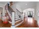 Elegant foyer with hardwood floors, a staircase with iron balusters, and an arched doorway to the dining room at 4729 Adler Pass, Raleigh, NC 27612