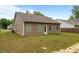 The backyard features a grassy area and a simple exterior of the house with beige siding and a door at 5081 Pioneer Dr, Sanford, NC 27330