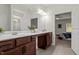 Bathroom featuring double sinks, a large framed mirror, and access to the main bedroom at 5081 Pioneer Dr, Sanford, NC 27330