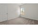 This bedroom features neutral walls and carpet, a window with blinds, and a white door at 5081 Pioneer Dr, Sanford, NC 27330