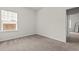 This bedroom features neutral walls and carpet, a window with blinds, and a white door at 5081 Pioneer Dr, Sanford, NC 27330