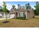 Charming home with stone accents, a two-car garage, landscaping, and a manicured lawn under a blue sky at 5081 Pioneer Dr, Sanford, NC 27330