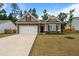 Charming single-story home featuring stone accents, a two-car garage, and a well-manicured front lawn at 5081 Pioneer Dr, Sanford, NC 27330