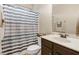 Bathroom featuring a shower-tub combo with gray striped curtain, single sink vanity, and mirror at 51 Balboa Pkwy, Clayton, NC 27520