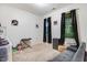 Cozy bedroom with neutral carpet, two windows with dark curtains, and a gray sofa at 51 Balboa Pkwy, Clayton, NC 27520
