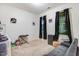 Cozy bedroom with neutral carpet, two windows with dark curtains, and a gray sofa at 51 Balboa Pkwy, Clayton, NC 27520