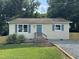 Charming single story home with beige siding, blue shutters and entry door, and a well kept yard at 510 North St, Graham, NC 27253