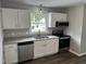 Modern kitchen featuring white cabinets, stainless steel appliances, granite countertops and updated flooring at 510 North St, Graham, NC 27253