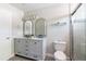 Modern bathroom featuring double vanity, two mirrors, and glass door shower at 5200 Fieldwood Ct, Raleigh, NC 27616