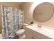 Bathroom vanity with round mirror and decorative shower curtain at 5200 Fieldwood Ct, Raleigh, NC 27616