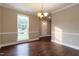 View of the dining room with hardwood floors, a window, and a modern chandelier at 5200 Fieldwood Ct, Raleigh, NC 27616