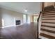 Spacious living room featuring a cozy fireplace, modern ceiling fan, and staircase at 5200 Fieldwood Ct, Raleigh, NC 27616