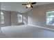 Large main bedroom with neutral carpet, ceiling fan, and three sunny windows at 5200 Fieldwood Ct, Raleigh, NC 27616