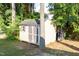 Outdoor storage shed with double doors surrounded by mature trees, located in backyard at 5200 Fieldwood Ct, Raleigh, NC 27616