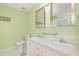 Bathroom features a double sink vanity, toilet, tile flooring and green walls at 559 Blue Pond Rd, Clayton, NC 27520
