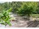 Outdoor deck with seating, a white metal table and a view of the well maintained backyard at 559 Blue Pond Rd, Clayton, NC 27520