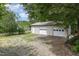 A detached two car garage featuring two doors, white trim and gravel driveway at 559 Blue Pond Rd, Clayton, NC 27520
