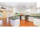 Open kitchen boasts white cabinets, stainless steel appliances, breakfast bar, and hardwood floors at 559 Blue Pond Rd, Clayton, NC 27520