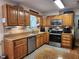 Well-appointed kitchen featuring updated appliances, wood cabinets, and granite countertops with a tile backsplash at 5760 Hesters Store Rd, Hurdle Mills, NC 27541