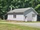 Outbuilding featuring a garage door, side entry door, and an adjacent covered space at 5760 Hesters Store Rd, Hurdle Mills, NC 27541