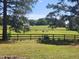Scenic view of horses grazing in a lush green pasture surrounded by a wooden fence on a sunny day at 5760 Hesters Store Rd, Hurdle Mills, NC 27541