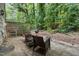 Private backyard patio with patio set and grill, surrounded by mature trees at 6021 Dixon Dr, Raleigh, NC 27609