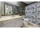 Bathroom featuring vintage wallpaper, vanity with ample counter space and walk-in shower at 6021 Dixon Dr, Raleigh, NC 27609