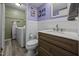 Bathroom featuring a wood cabinet, marble countertop, and laundry appliances in an adjacent room at 6021 Dixon Dr, Raleigh, NC 27609