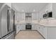 Bright kitchen boasts stainless appliances, shaker cabinets, and updated lighting fixtures at 620 Red Carriage Ave, Durham, NC 27704