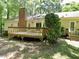Cozy home featuring a spacious wooden deck and a brick chimney in a lush, wooded backyard at 637 Shadywood Ln, Raleigh, NC 27603
