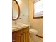 Cozy bathroom with wood vanity, framed mirror, toilet and natural light from the window at 637 Shadywood Ln, Raleigh, NC 27603