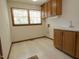 Functional laundry room with sink, storage cabinets, and a window for natural light at 637 Shadywood Ln, Raleigh, NC 27603