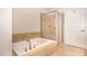 Bathroom featuring a soaking tub with shower, tile walls, and tile floors at 7250 Nc 751 Highway, #1205, Durham, NC 27707