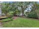 Large grassy yard with a wooden fence at 8 Great Oak Ct, Durham, NC 27713