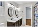 Bright bathroom features a double vanity with white countertop and oval mirrors at 8 Great Oak Ct, Durham, NC 27713