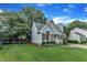 Landscaped home with blue siding, pretty lawn, driveway, mature trees, and blue sky at 8 Great Oak Ct, Durham, NC 27713