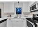 Bright kitchen boasts white cabinets, stainless steel appliances, and quartz countertops at 8 Great Oak Ct, Durham, NC 27713