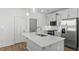 Bright open kitchen with modern appliances, a large island with bar seating and stainless steel refrigerator at 807 Outlaw Ave # 19, Durham, NC 27703