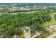 An aerial view of houses nestled among tall, lush green trees in a quiet neighborhood setting at 8116 Mosby Way, Willow Springs, NC 27592