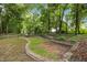 Tranquil backyard featuring a hammock, retaining wall and mature trees providing ample shade at 8116 Mosby Way, Willow Springs, NC 27592